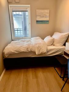 a bed sitting in a room with a window at Tjuvholmen / Aker Brygge - Most expensive area in Oslo! in Oslo