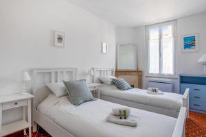 sypialnia z dwoma łóżkami i lustrem w obiekcie Maison Castel - Welkeys w mieście Tulon