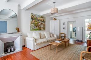 Maison Castel - Welkeys في تولون: غرفة معيشة مع أريكة بيضاء ومدفأة