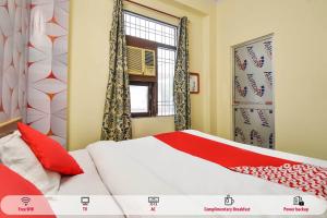 um quarto com uma cama com almofadas vermelhas e uma janela em Super OYO Pragati Inn em Jaipur