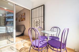 a room with purple chairs and a table and a balcony at Apartamentos Lepanto 21 Levante Area in Benidorm