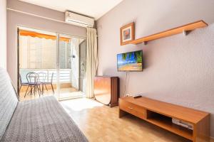a bedroom with a bed and a tv and a table at Apartamentos Lepanto 21 Levante Area in Benidorm