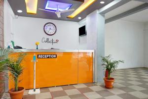 Hotel Eon Inn Near Pune Airport في Kharadi: باب برتقالي في الغرفة مع ساعة على الحائط