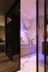 a bathroom with a tub and a marble wall at Suite Michelangelo in Brera in Milan