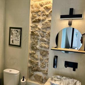 a bathroom with a stone wall and a mirror at La Casa Rebonita PICCOLA in Candelario