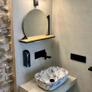 een badkamer met een marmeren wastafel en een spiegel bij La Casa Rebonita PICCOLA in Candelario