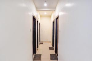 a hallway with doors and a tile floor at FabHotel Bliss Inn in Prayagraj