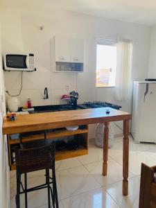 kuchnia z drewnianym stołem i lodówką w obiekcie NOVO APARTAMENTO Liz 1 w mieście Porto Seguro