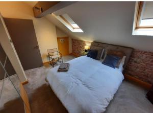 ein Schlafzimmer mit einem großen Bett und einer Ziegelwand in der Unterkunft The Mews in Alderley Edge