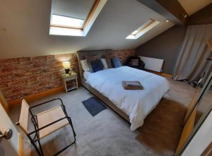 a bedroom with a bed and a brick wall at The Mews in Alderley Edge