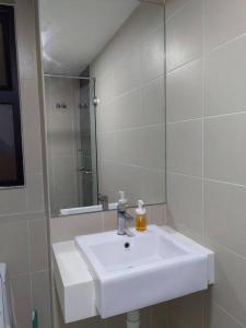 ein Badezimmer mit einem weißen Waschbecken und einem Spiegel in der Unterkunft KA1707 - Cyberjaya-Netflix-Wifi- Parking, 1005 in Cyberjaya