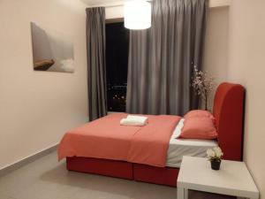 een slaapkamer met een rood bed en een raam bij KA1707 - Cyberjaya-Netflix-Wifi- Parking, 1005 in Cyberjaya