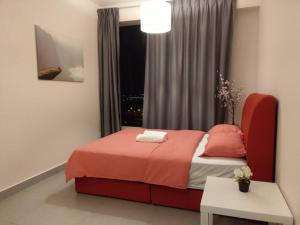 a bedroom with a red bed and a window at KA1707 - Cyberjaya-Netflix-Wifi- Parking, 1005 in Cyberjaya