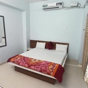 a bed in a small room with avertisement for at hotel adiraj palace and lodging in Sonai