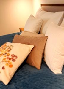 uma cama com almofadas brancas e um cobertor azul em Falcon Apartment Center 2 Metro Złote Tarasy em Varósvia