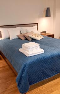 1 cama con manta azul y almohadas en Falcon Apartment Center 2 Metro Złote Tarasy, en Varsovia