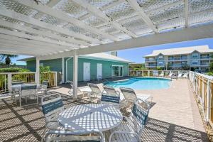 a patio with a table and chairs and a pool at Beach Bella-Quiet 3BR-3 Min to the Beach in Destin
