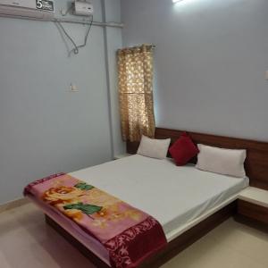 a small bedroom with a bed with a window at hotel adiraj palace and lodging in Sonai