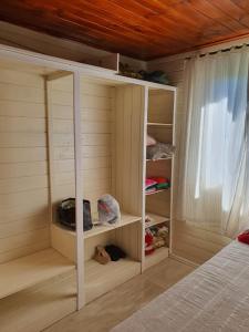 a room with a closet with shelves and a bed at Casa p fim de semana in Urupema