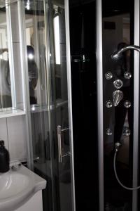 uma casa de banho com uma cabina de duche em vidro e um lavatório. em Villa Branko em Vodice