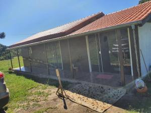 a house with a screened in porch with a hose at Casa p fim de semana in Urupema