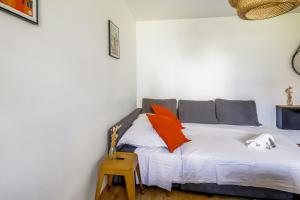 リヨンにあるModern flat near Part-Dieu in Lyon - Welkeysのベッドルーム1室(オレンジとグレーの枕が備わるベッド1台付)