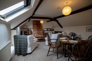 a living room with a table and chairs at The Old Plough, mix of 1 bed and 3 bed units, rustic charm, super king bed or twins, en-suite, secure parking in Caldecott