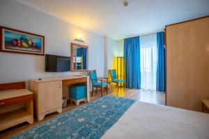 Habitación de hotel con cama y escritorio en Stella Beach Hotel Ultra All Inclusive, en Okurcalar