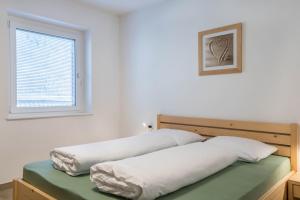 ein Schlafzimmer mit zwei Kissen auf einem Bett und einem Fenster in der Unterkunft Talhaus - Robert in Ponte Nova