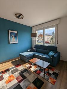 a living room with a blue couch and a table at Maison Alice in Saint Vincent