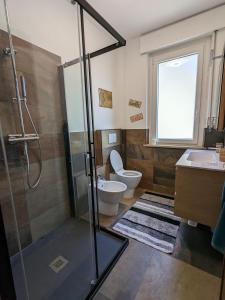 a bathroom with a shower and a toilet and a sink at Maison Alice in Saint Vincent