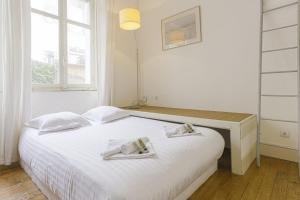 sypialnia z białym łóżkiem i 2 ręcznikami w obiekcie Appartement Gardague - 2 étoiles - Welkeys w Biarritz