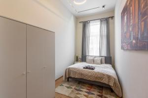 1 dormitorio con cama y ventana en Exclusive Rákoczi Residence by Anna en Budapest