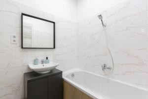 y baño blanco con lavabo y bañera. en Exclusive Rákoczi Residence by Anna en Budapest