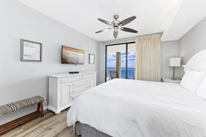 a bedroom with a white bed and a ceiling fan at Summer House 1105A in Orange Beach