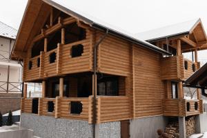 uma casa de madeira com um telhado de gambrel em Solid Village em Migovo