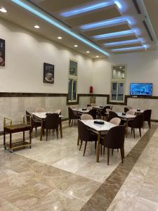 فندق الورد الذهبي في الطائف: مطعم فيه طاولات وكراسي في الغرفة