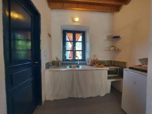 uma cozinha com um lavatório e uma janela em Arancio independent room in Ecovilla on the beach em Apolakkiá