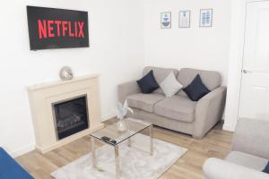 a living room with a couch and a fireplace at Modern 3 Bed House in Wolverhampton
