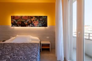 1 dormitorio con 1 cama y una pintura en la pared en Clipper, en Pesaro