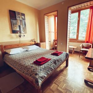 um quarto com uma cama com duas toalhas vermelhas em Malvy hotel em Truskavets