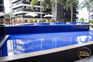 una piscina azul con un edificio de fondo en Landscape Flat Charmoso Condomínio na Beira Mar, en Fortaleza