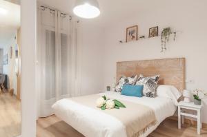 een witte slaapkamer met een groot bed met blauwe kussens bij Apartamento con terraza y vistas al canal by InsideHome in Empuriabrava