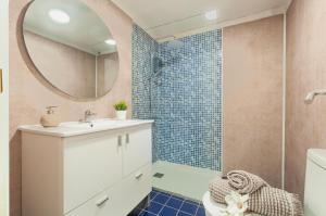 een badkamer met wastafel en douche met spiegel bij Apartamento con terraza y vistas al canal by InsideHome in Empuriabrava +34 foto's