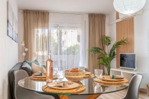een eetkamer met een glazen tafel met eten erop bij Apartamento con terraza y vistas al canal by InsideHome in Empuriabrava
