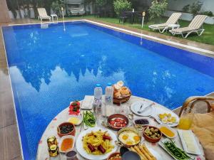 GARDEN OTEL AMASYA في أماصيا: طاولة طعام بجوار حمام سباحة
