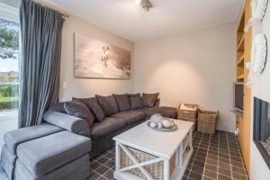 uma sala de estar com um sofá e uma mesa em Luxe familievilla voor 9pers met zee en tuinzicht em Koksijde