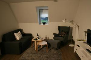 ein Wohnzimmer mit Sofa, Sessel und Tisch in der Unterkunft ApartPeterstor in Montabaur