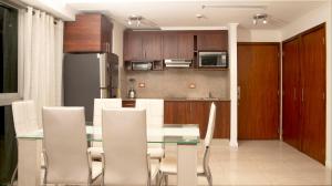 a kitchen and dining room with a glass table and white chairs at Edificio Torres del sol in Guayaquil
