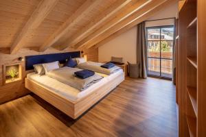 a bedroom with two beds and a large window at Riedbergerhorn - Gasthof & Ferienwohnungen in Bolsterlang